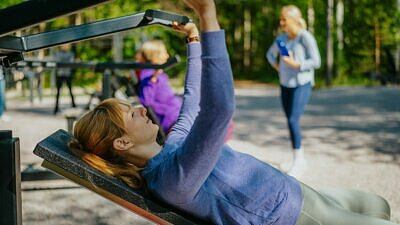 Kvinna som tränar på utegym.