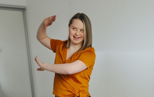 Ung kvinna med Downs syndrom i orange top.