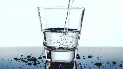 Halvfullt glas med vatten som fylls på.