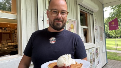 Dan Ström håller upp en våffla med grädde, sylt och glass