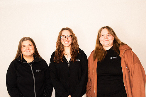 Foto på de tre nya fältarna, tre unga kvinnor ler ståendes mot en vit vägg