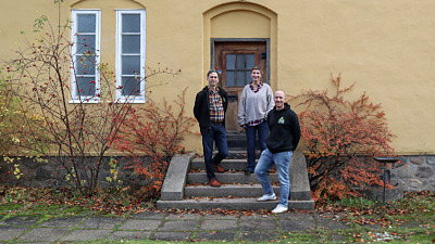 Projektledarna för LINK står framför ett gult hus