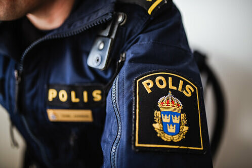 Närbild av polispersons arm med Polisens emblem