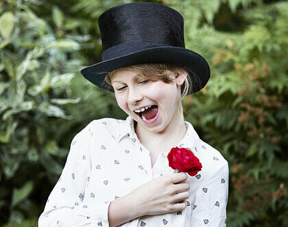 En flicka i hatt som skojar och leker.